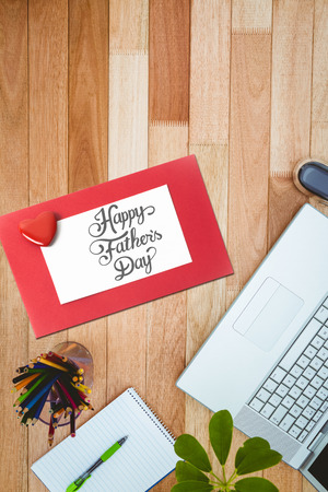 fathers day greeting against business desk with laptop and colors pencilの写真素材