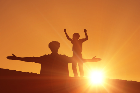 Smiling boy jumping against cloudsの写真素材
