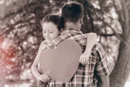 Father and daughter hugging in the park on a sunny dayの写真素材