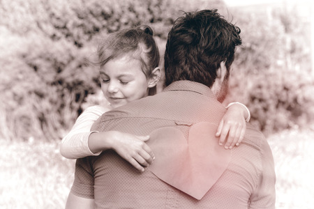 Daughter giving dad a heart card in the countrysideの写真素材
