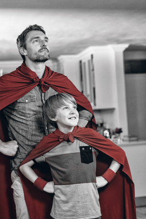 Father and son pretending to be superhero in living room at homeの写真素材