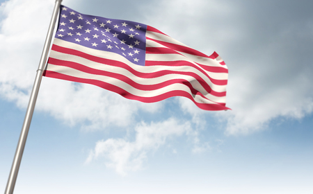 Low angle view of American flag against cloudy sky backgroundの写真素材
