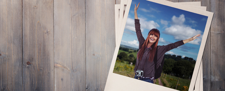 Side view of a hipster woman with a travel bag against pale grey wooden planksの写真素材