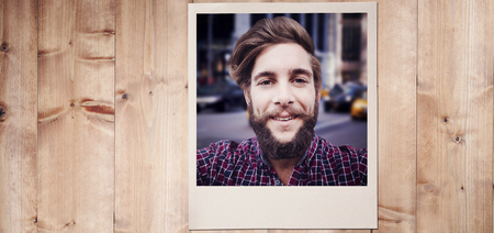 Happy hipster against wooden fence against wooden planks
