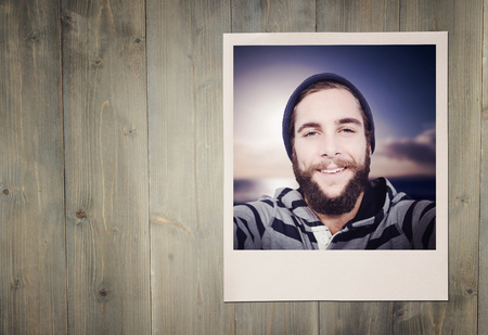Happy hipster against wooden fence against wooden planksの写真素材