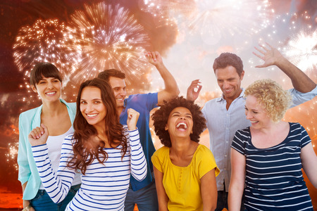 Creative business team having fun  against colourful fireworks exploding on black backgroundの写真素材