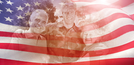 Portrait of army man with parents against digitally generated american flag ripplingの写真素材