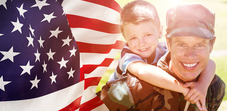Focus on usa FLAG against happy soldier giving piggyback to his sonの写真素材