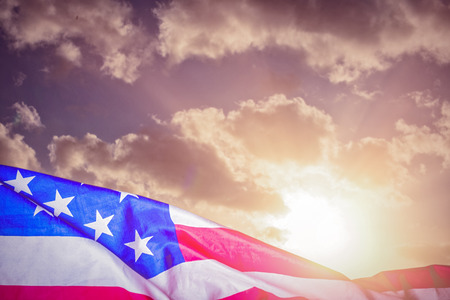 Creased US flag against cloudy skyの写真素材