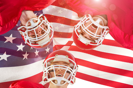 American football huddle against focus on usa flagの写真素材