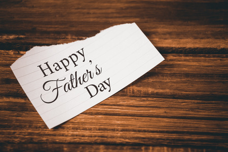 Happy fathers day message on a paper on wooden tableの写真素材