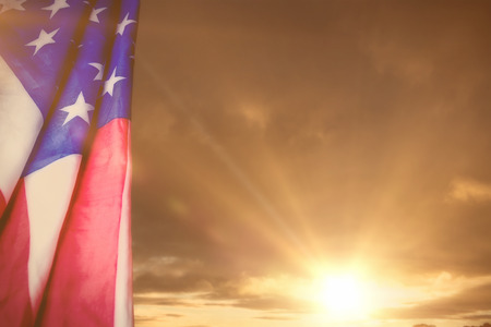Creased US flag against cloudy skyの写真素材