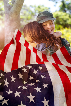 Focus on usa FLAG against happy soldier reunited with her daughterの写真素材
