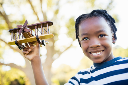 Happy child holding a plane at parkの写真素材
