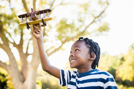 Happy child playing with a plane at parkの写真素材