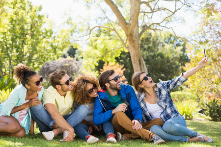 Group of friends taking a selfie with the mobile phone in park