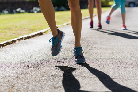 Female athletes feet running on running track in parkの写真素材
