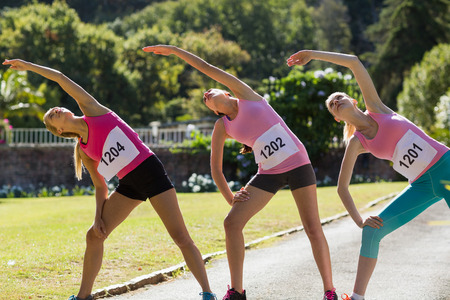 Female athletes warming up in park on a sunny day