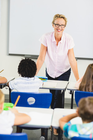 Happy teacher teaching in classroom at schoolの写真素材