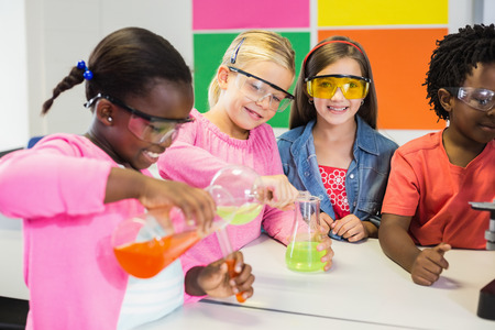 Kids doing a chemical experiment in laboratory at school