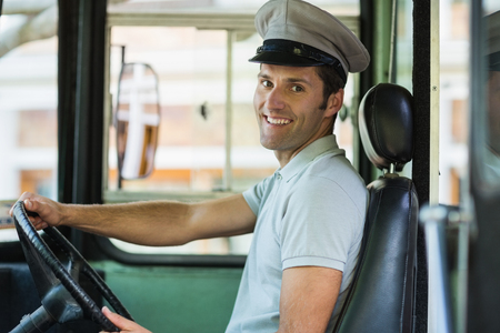 Portrait of smiling bus driver driving a busの写真素材