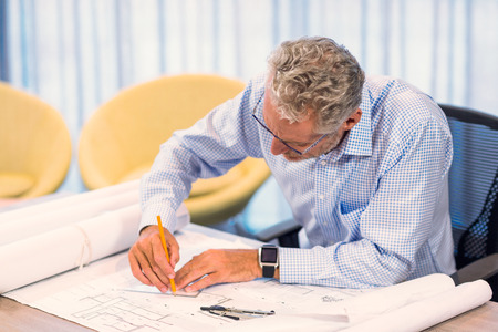 Man working on blueprint in office