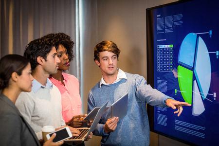 Business people looking at a graph in the conference room at office