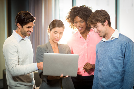 business people having discussion over laptop in officeの写真素材