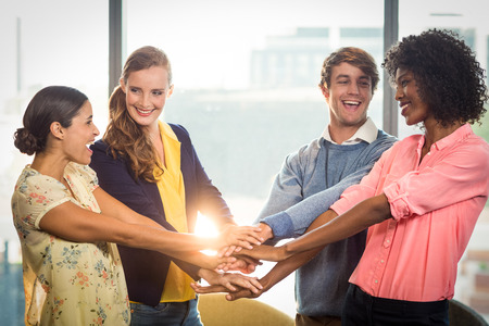 Business people forming hands stack in office