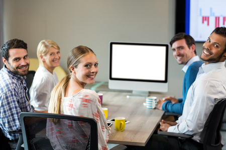 Business people smiling at camera during a video conference in the conference room