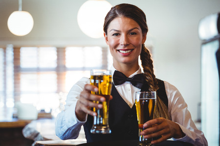 Waitress holding beers in a restaurant