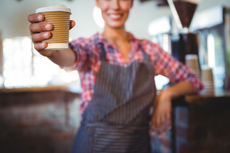 Waitress holding a cup of coffee in a cafeの写真素材