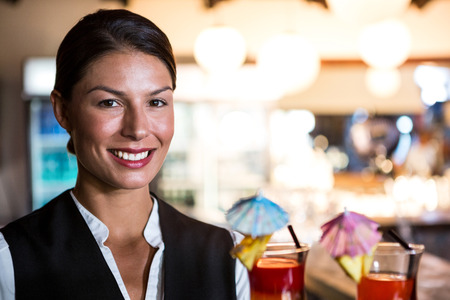 Waitress holding cocktails in a restaurantの写真素材