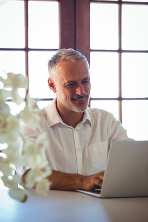 Man using a laptop in a restaurantの写真素材