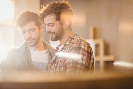 Graphic designer using digital tablet with his coworker in the officeの写真素材