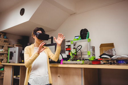 Female graphic designer using the virtual reality headset at office