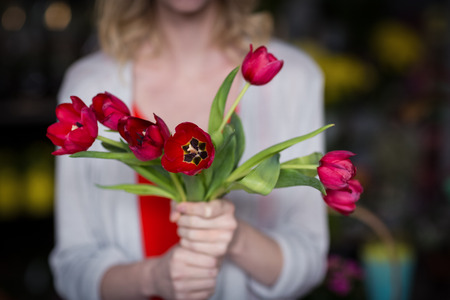Mid section of female florist holding bunch of flower in the shopの写真素材