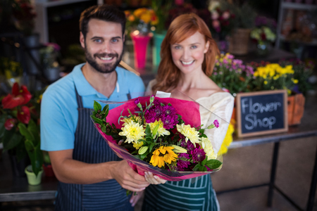 Portrait of couple holding flower bouquet in the flower shopの写真素材