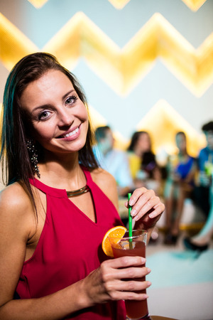 Portrait of young woman having a cocktail in barの写真素材