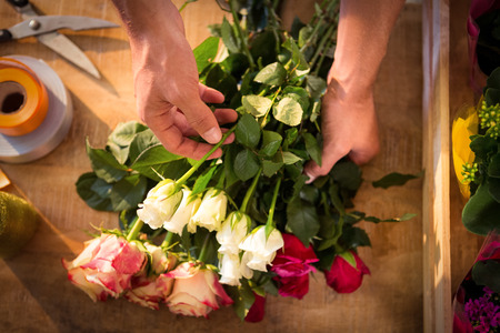 Male florist preparing flower bouquet at his flower shopの写真素材
