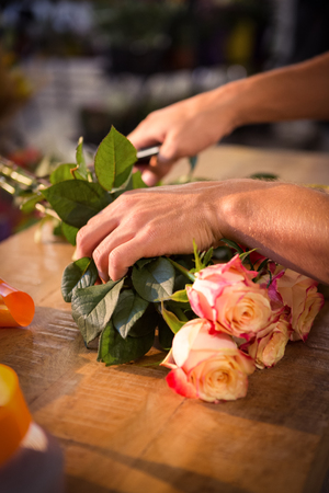 Male florist preparing flower bouquet at his flower shopの写真素材