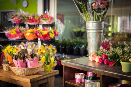 Plant pots and bouquet on table at flower shopの写真素材