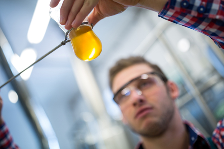 Close-up of brewer testing beer at brewery factoryの写真素材