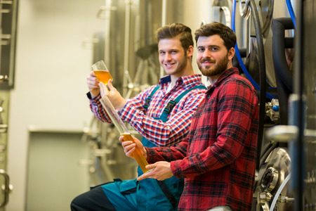 Portrait of brewers testing beer at brewery factoryの写真素材