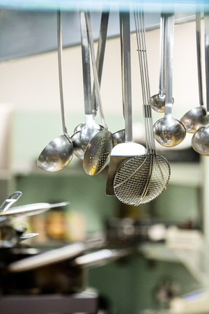 Close-up of hanging kitchen utensils in restaurantの写真素材