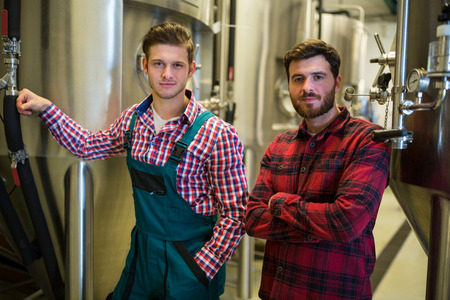 Portrait of brewers with arms crossed at breweryの写真素材