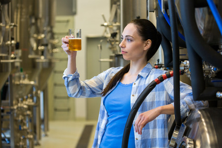 Beautiful female brewer testing beer at beweryの写真素材