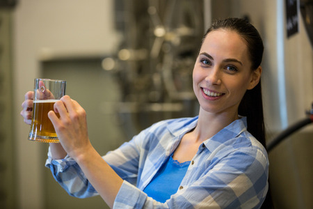 Portrait of happy female brewer testing beer at breweryの写真素材