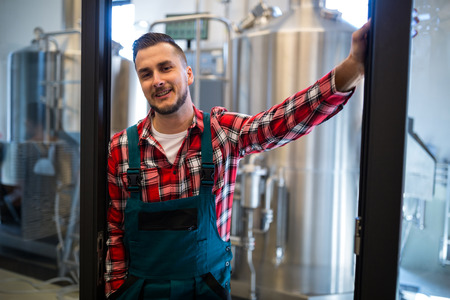 Happy brewer standing at breweryの写真素材
