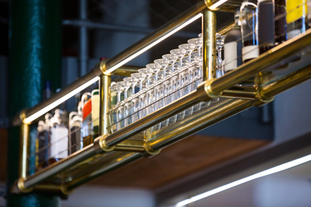 Wine glass arranged in bar rack at barの写真素材